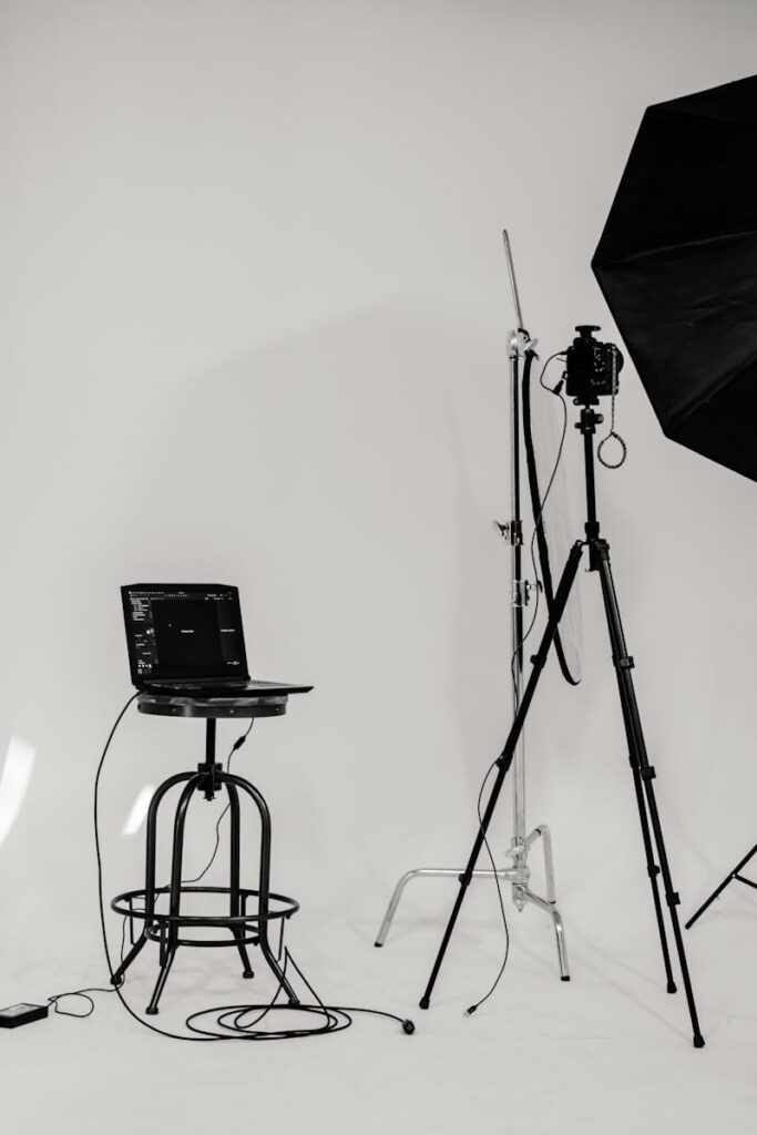 A black and white photo of a well-equipped photography studio with lighting equipment and tripods.