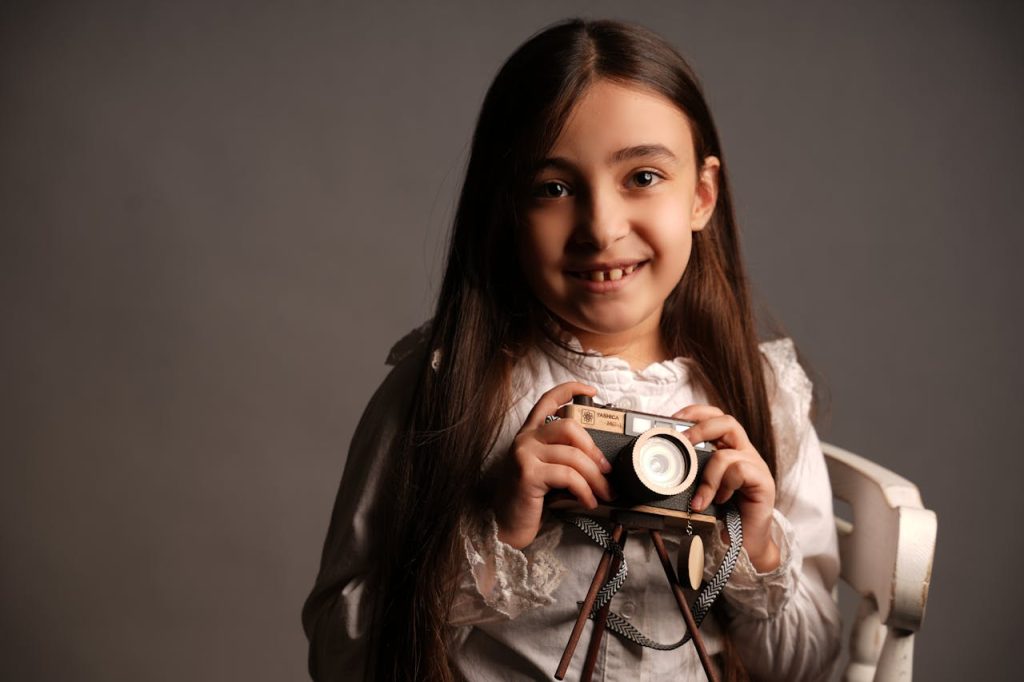 smiling-girl-holding-a-vintage-camera-30044976